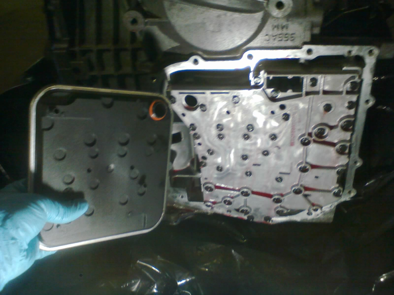 With the park rod locked into position, the valve body can be popped into place and bolted in. A new filter gets firmly pressed onto the valve body.